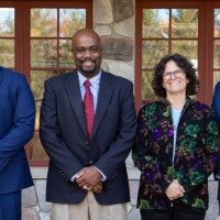 Four award recipients pose together outside of Alumni House